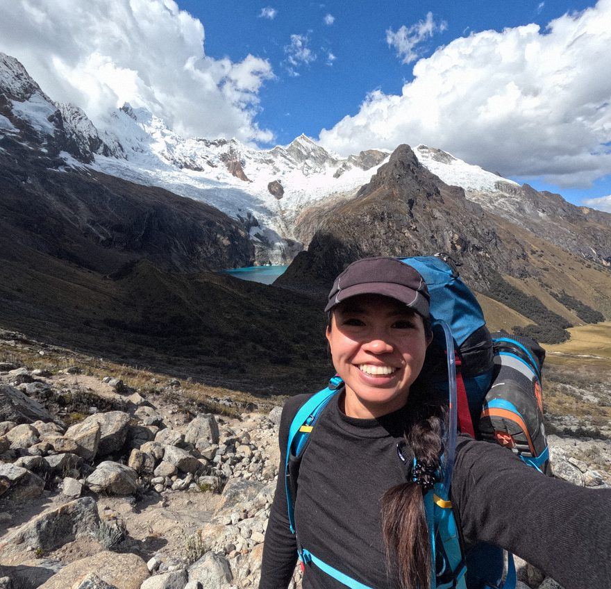 Christina on the trail, glacier and turquoise lake behind her